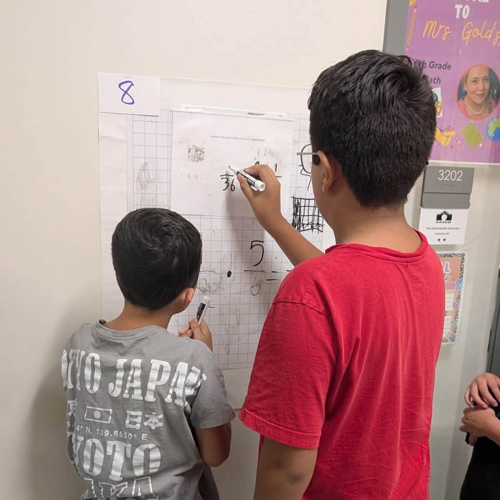 Boys solve math problems on wall