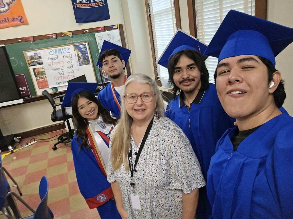 teacher with students in graduations gowns