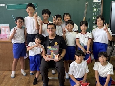 student reading to younger children in uniform
