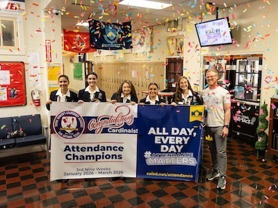Young Women's Leadership Academy students and administration with Attendance Champion banner