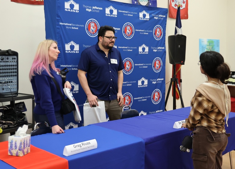 Student visits with panel members after session