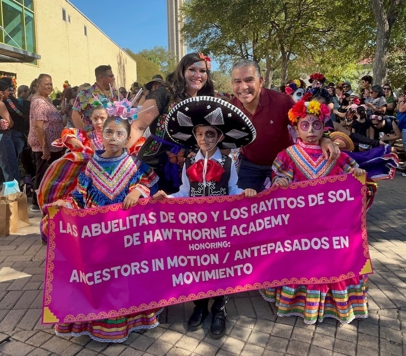 Dr. Aquino with Hawthorne folklórico holding pink banner