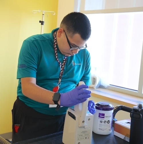 Intern cleans medical equipment