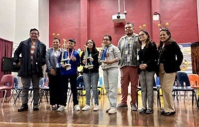 Students and teachers holding trophies