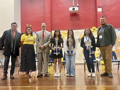 Students and teachers holding trophies