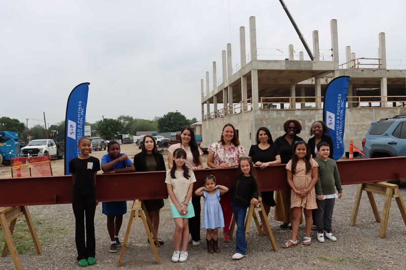 Highland Hills students and faculty stand around final beam