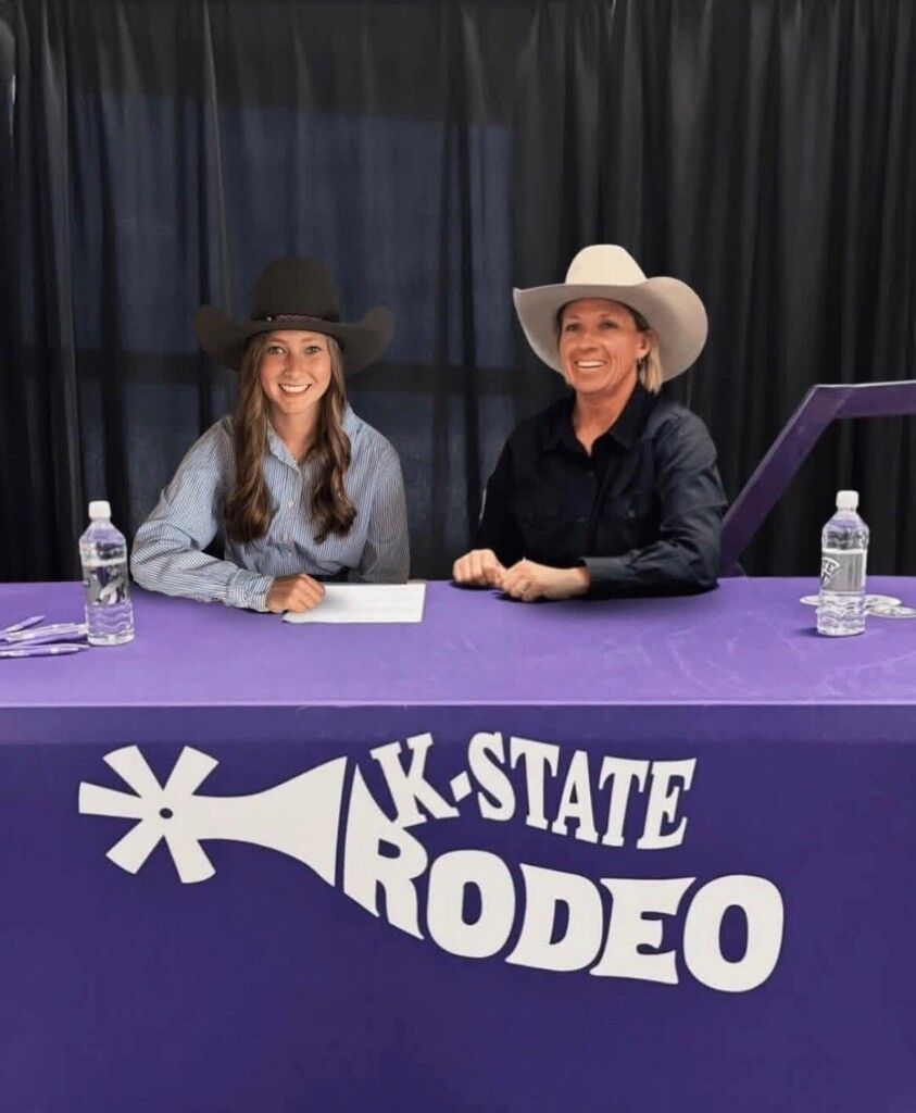 Ava signing with her coach from Kansas State