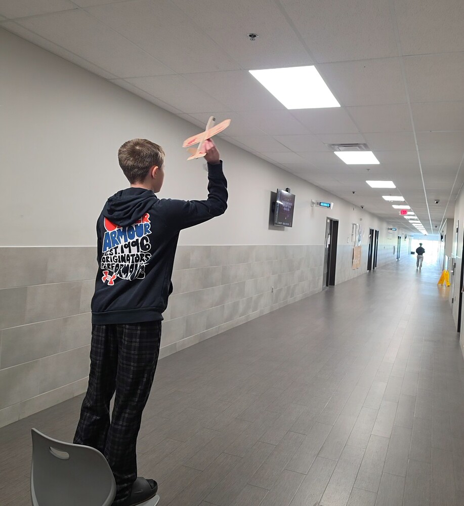 Student throwing a wooden plane