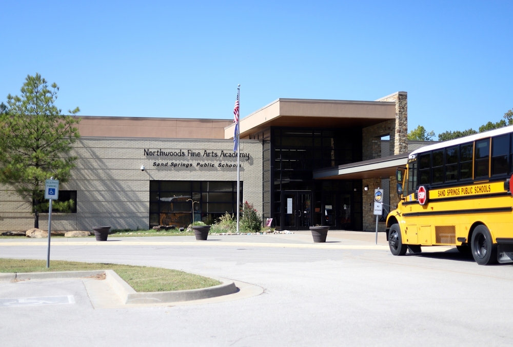 Exterior shot of Northwoods Fine Arts Academy with a yellow school bus parked outside.