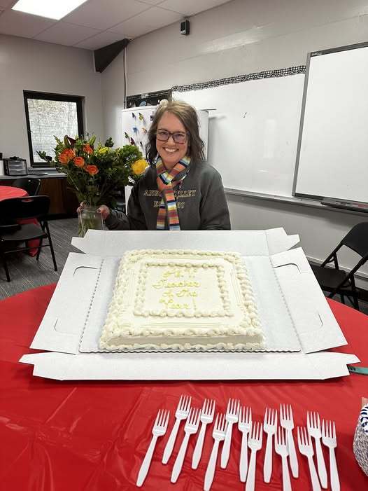 Mrs. Laura McGehee holds up a cake reading "AV Teacher of the Year"!