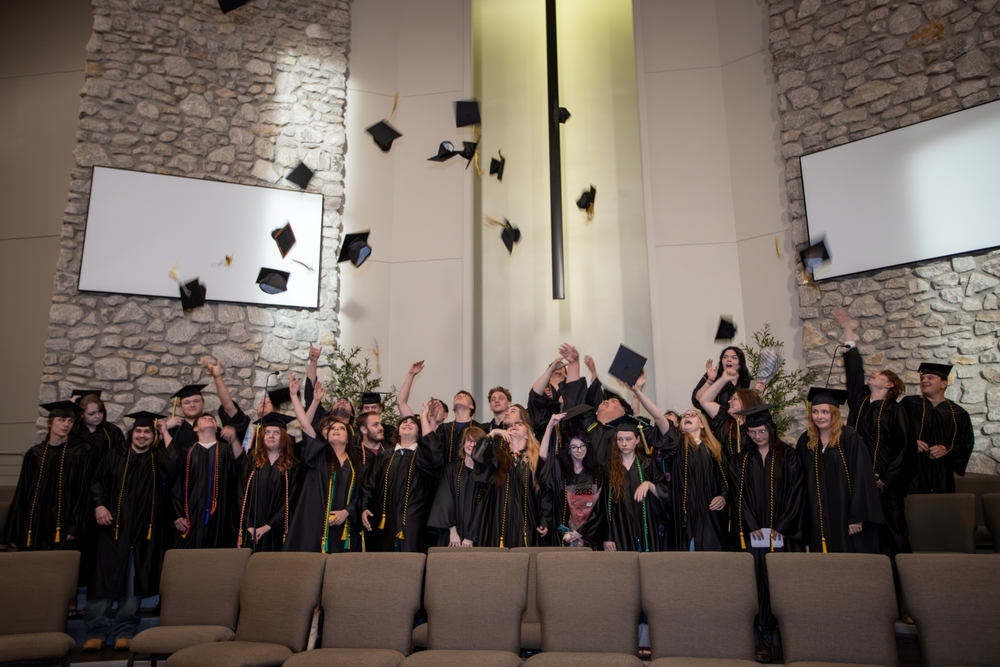 Graduates tossing their graduation caps in the air.