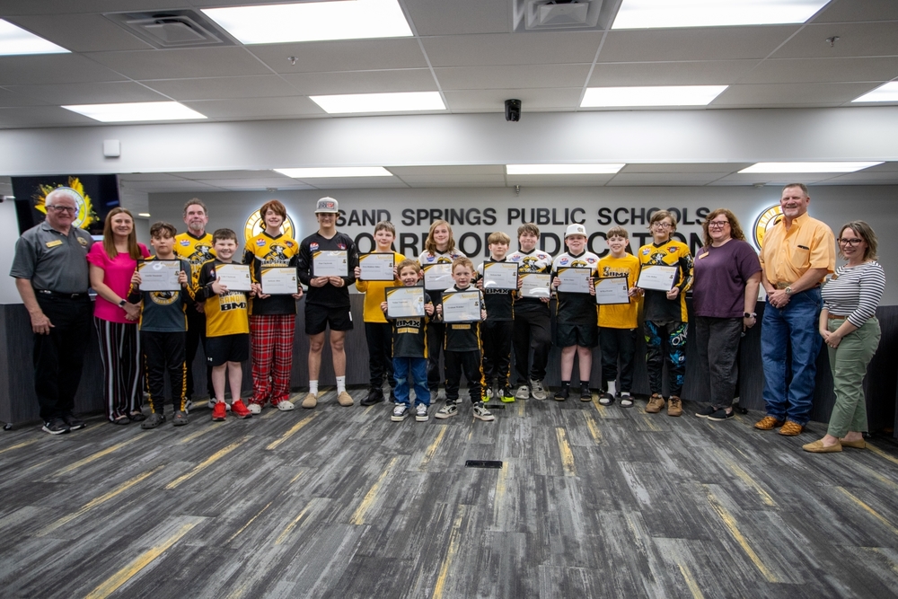 BMX Team and coach receive certificates of recognition from School Board members.