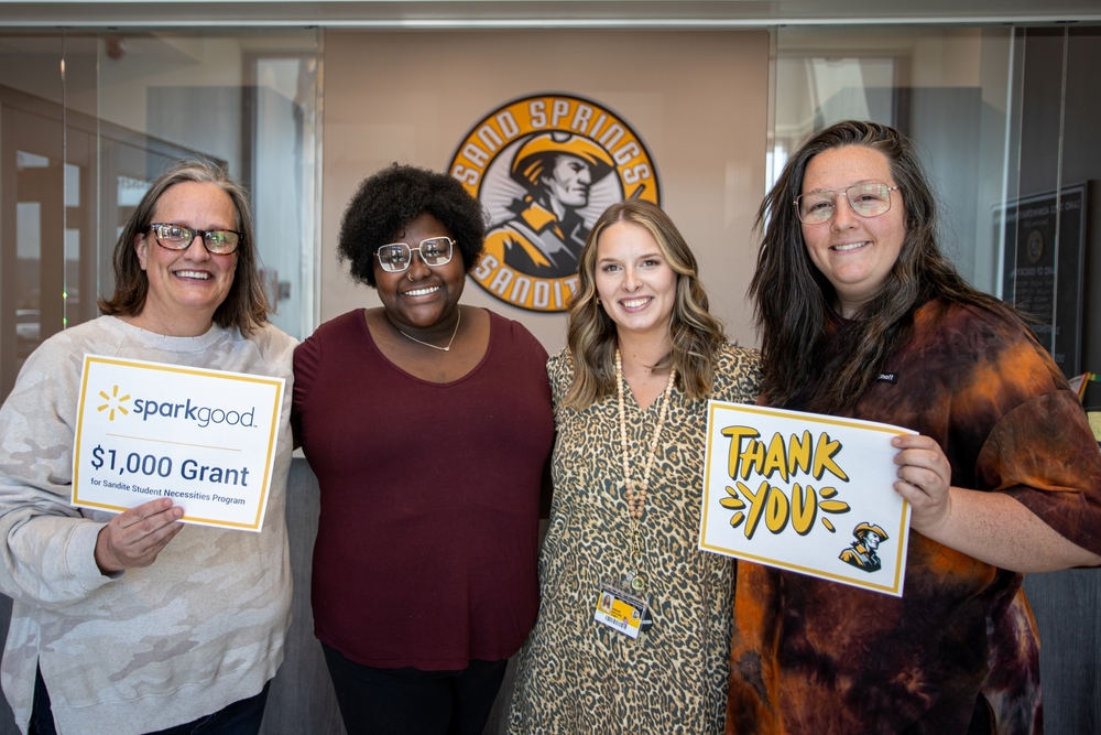 School district employees holding signs expressing thanks to Spark Good for a $1,000 grant.