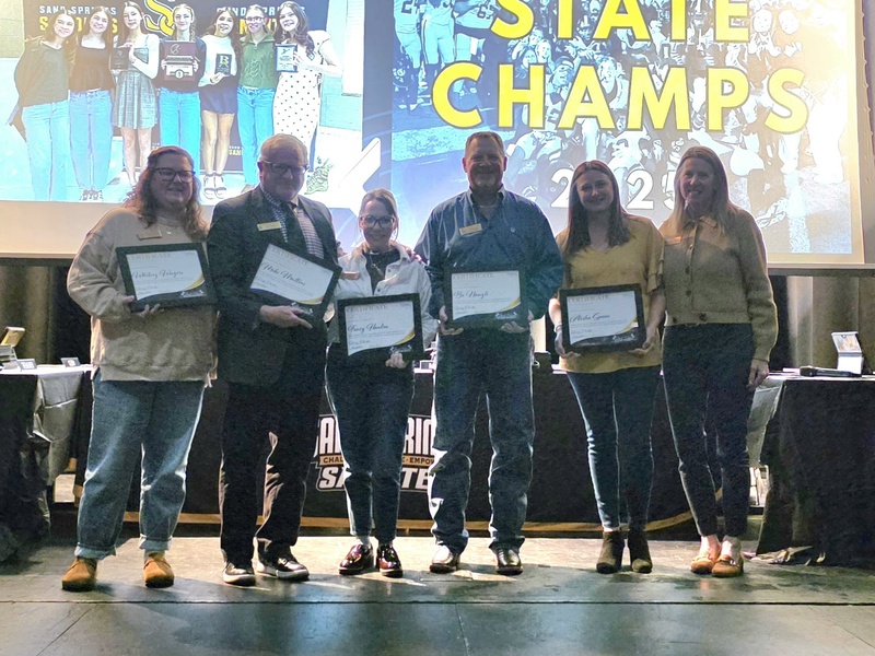 Sand Springs Board of Education on stage holding certificates of recognition