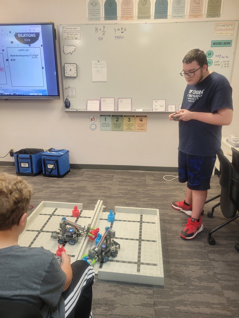 Students driving robots to stack cones as a design testing process.