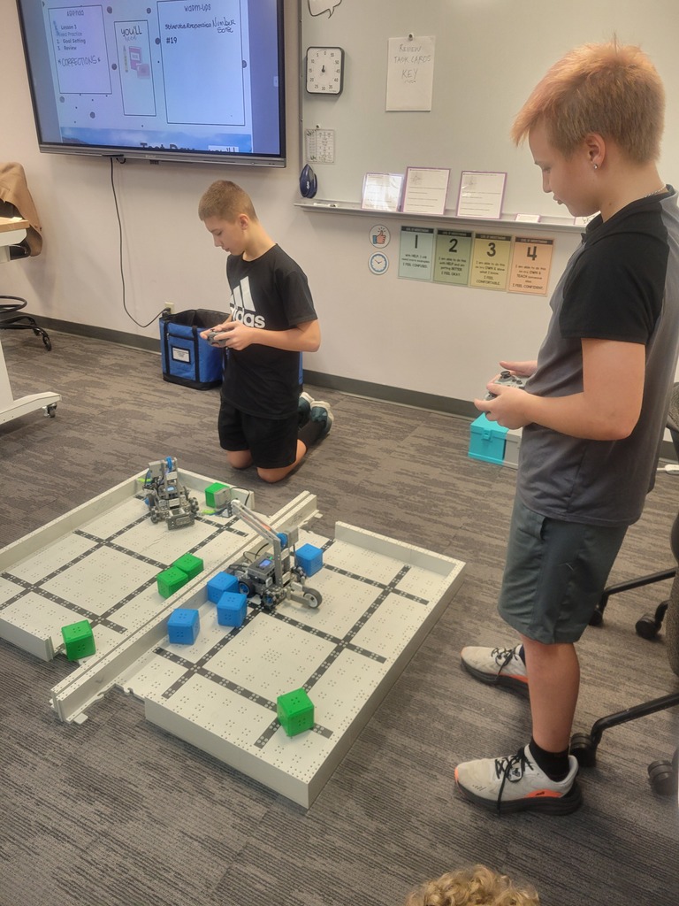 Students driving robots to stack blocks and test their design