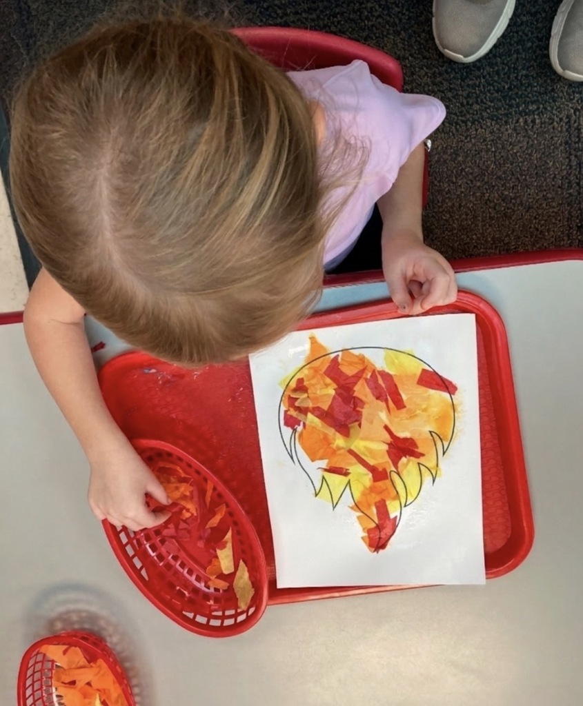 Preschool student crafting a fire.