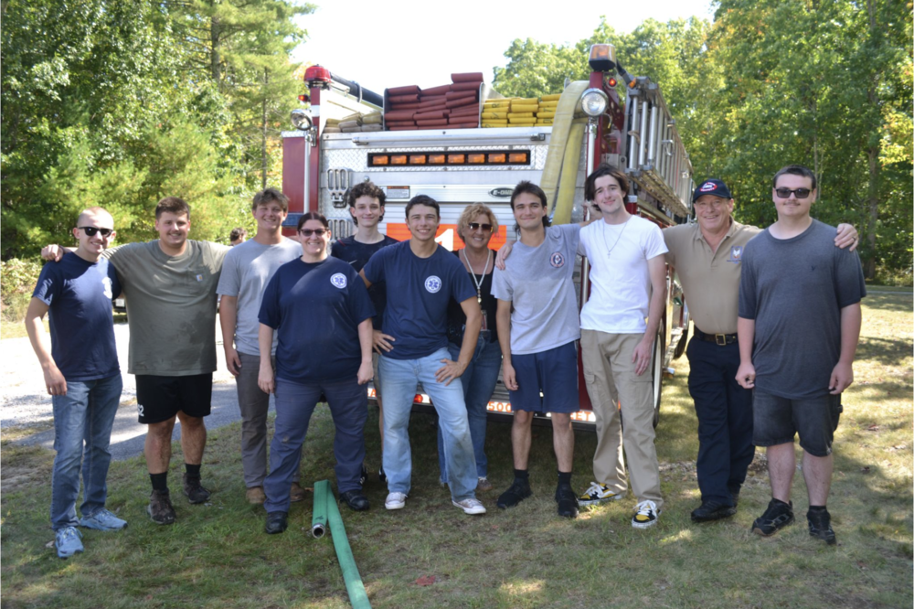 SRTC students pose for a photo with first responders in front of a fire truck.
