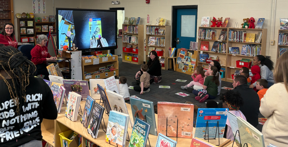 When Shana Palmer, First 10 Coordinator for the Sanford School Department, launched her Play and Learn sessions, she designed them with the youngest learners in mind: children from birth to age five and their families. But what she's found is that the program's warmth and energy have a way of drawing in the whole family, regardless of age. ​​First 10 is an early childhood initiative that supports children and families during the critical first ten years of life. Palmer's Play and Learn sessions are a cornerstone of that work. Sanford Pride Ed Tech Terri Gerrish has also been instrumental in assisting with the Play and Learn sessions, which are welcoming gatherings where young children and their caregivers can enjoy story time, music and movement, hands-on educational activities, and the chance to connect with school staff, community providers, and other parents.  Fallon Cote, a 3rd grader at Pride Elementary, has become a fixture at the monthly Play and Learn sessions. She shows up on the first Monday of each month, helps Palmer run the activities, and engages with the younger children, which is entirely on her own initiative. Her mom Samantha Mercier brings the whole family, but it's Fallon who has taken on a helper's role and made it her own. When asked about her experience, she was straightforward: "I'd say my favorite part is the coloring. I also like learning as well. That's fun." Her mom has noticed the program's impact on the whole family. "It's always been nice," she shared. "Some of the games that Ms. Shana does on the Wednesday sessions, I had to go home and recreate them." For Palmer, that's exactly the point: building connections and sparking learning that families carry with them long after the session ends. Play and Learn sessions feature themed, hands-on activities blending storytelling, movement, and creative exploration. At a recent dinosaur-themed evening, families stretched a long string down the hallway to measure the length of a seismosaurus, made dinosaur shapes with blocks, and colored. The turnout was one of the biggest the Monday series has seen. The monthly sessions run from 3:30 – 5 p.m. the first Monday of the month in the Pride Elementary library and are open to all Sanford families. The weekly Wednesday morning sessions are held from 9:30–11 a.m. at Springvale First Baptist Church, which generously provides both the space and snacks. Those sessions are co-facilitated by MaineHealth Sanford Pediatrics and Kids Kove Childcare and Early Learning Center, with additional support from Marisa Stam through the John T. Gorman Foundation grant. Both series are completely free and open to all Sanford families. To learn more or sign up, email Shana Palmer at spalmer@sanford.org.