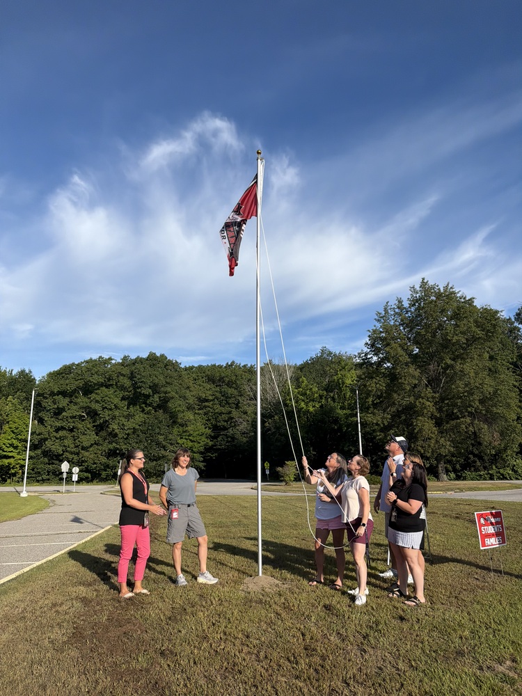 Staff raising flag
