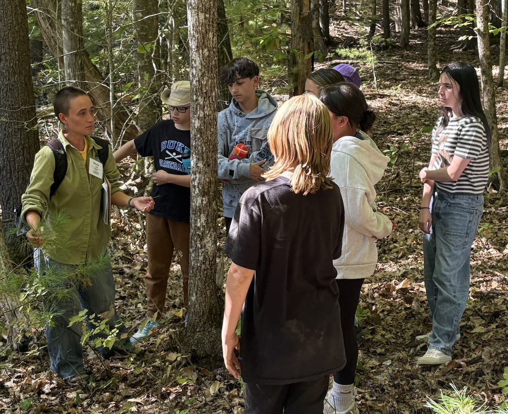Sanford Middle School seventh graders experienced hands-on outdoor learning at The Ecology School in Saco last week, participating in an overnight, three-day program that combined hands-on learning with community building in ways that will positively impact students. The Ecology School has formed partnerships with seven other outdoor education providers across Maine to increase program availability and has made the study of ecology accessible and enjoyable for people since 1998. The school is designed for immersive programs where students learn about conservation, farming, ecology, and sustainability through hands-on, fun activities. The trip was the result of planning and collaboration spearheaded by SMS science teacher Diana Allen. The planning also involved careful investigation and getting approval from school administration and the school committee. This vision became reality through Maine's new Outdoor School for All Maine Students Program, recently signed into law by Governor Mills, which aims to increase access to outdoor learning programs. The Ecology School is part of this statewide initiative, and each network partner gets to select a Maine school to receive scholarships for students to attend. The Ecology School's first choice was Sanford Middle School.  The only cost to the school department was for transportation to and from the Ecology School. The setting proved as important as the curriculum itself. The school's location right on the banks of the Saco River, complete with a granite amphitheater and open-air facilities, created a learning environment where natural sunlight and fresh air enhanced each lesson. "This is phenomenal experiential learning," said Sara Nason, a Sanford Middle School teacher who helped chaperone the trip. All classes took place outdoors in natural settings, with students moving between different ecological sites and building knowledge as they explored. During their stay, students participated in hands-on lessons that brought science standards to life. All lessons aligned with Common Core and Next Generation Science Standards, but rather than feeling like traditional classroom work, each activity felt like discovery.  In 'Battle of the Biotic,' they explored the roles of producers, consumers and decomposers in forest ecosystems, discovering how organisms compete for survival and examining predator-prey relationships. The 'Watersheds' lesson had students investigating how water flows and changes landscapes as it travels from mountain to sea, learning about weathering and erosion. Through the 'ABCs of Ecology' lesson, students gained foundational knowledge about abiotic factors like soil and climate, biotic organisms like plants and animals, and the cycles and changes that shape ecosystems. While students certainly learned about ecology – as 7th grader Kaydence Adjutant shared, "I learned that mushrooms decompose acorns" – some of the most meaningful learning happened through relationships and life skills developed during their time together.  Allen found the community-building aspect particularly meaningful. "The opportunity to spend these days with my students in nature, creating a sense of community, sharing laughter is something I will cherish throughout the school year," Allen said. When asked about the overnight experience, Adjutant captured the spirit perfectly: "It's really fun. Yeah, it's like one big sleepover with my class." "The comments that we're hearing are, 'Well, this is kind of cool,'" Nason explained. "'All sitting down together for a meal.'" Students also learned important life skills like cleaning up after themselves and taking care of shared spaces. Allen was moved by watching her students adapt to the environment: "Watching them play, set tables, help each other - it was just incredible to see and be a part of." These experiences translated into practical learning that students brought home with them. Students returned with practical awareness about waste management, understanding how much food they actually need and how their choices affect the community. The program was such a success that Allen hopes it will become an annual tradition for Sanford seventh graders. "We are incredibly grateful to Drew Demsch and The Ecology School staff for this generous opportunity for our students," Allen added. The shared experience also gives teachers valuable insights into their students and creates positive reference points for future success and learning. "We now have something very much in common, something tangible and meaningful that we can build from," Nason said.