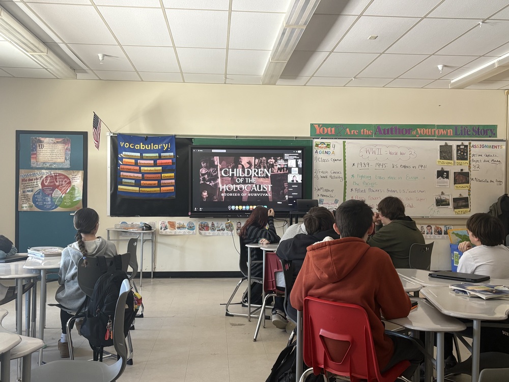 Sanford Middle School's seventh graders had a powerful and meaningful learning experience when they connected via Zoom with Ruth Wade, the daughter of Holocaust survivor Sydney Finkel. During the hour-long session on Wednesday, March 4,  Ms. Wade shared her father's remarkable story of survival.  From his childhood in Poland when Germany invaded, through the horrors of the concentration camps, to his eventual liberation. Students watched a documentary video featuring Mr. Finkel telling his story in his own words, and then had the opportunity to speak directly with Ms. Wade in a live question-and-answer discussion. What made the experience especially impactful was the conversation that followed the video. Ms. Wade guided students to reflect on the many individual choices — large and small — that shaped her father's survival: the family members who protected him, the strangers who took great personal risks to help, and even the simple acts of kindness that helped sustain him through unimaginable hardship.  Students engaged thoughtfully, identifying specific moments from the video and connecting them to a broader message about the choices we all make in our daily lives.