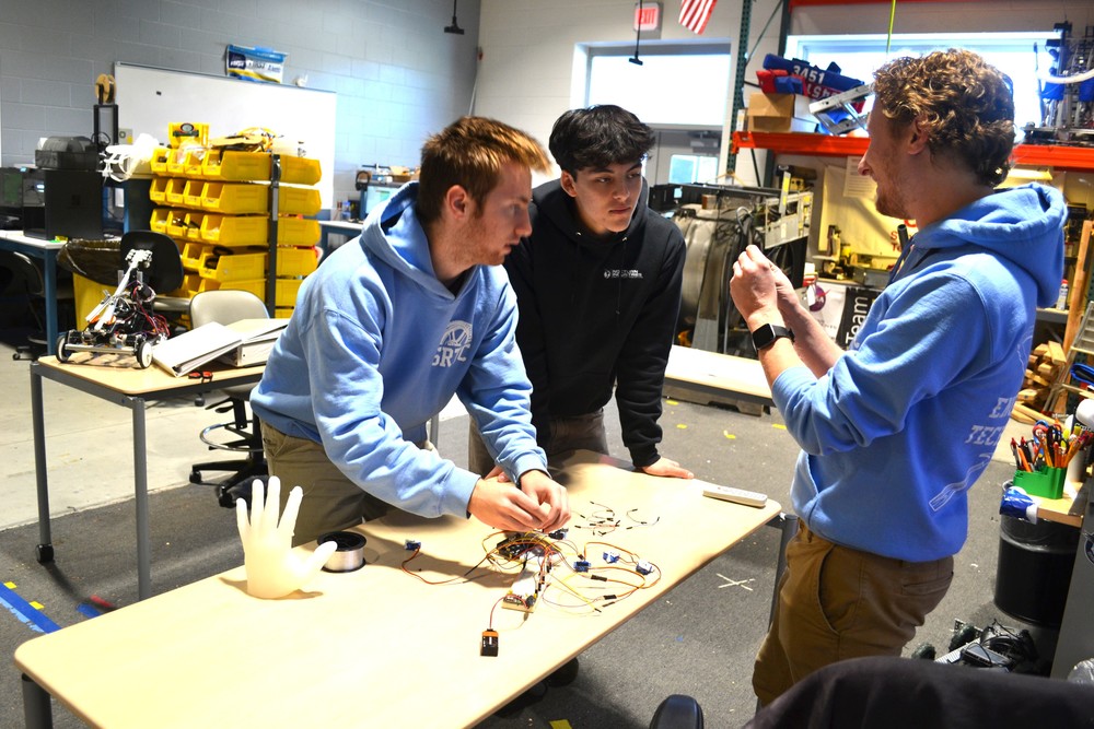 There's no single "right answer" in engineering, and that's exactly what makes SRTCās Engineering Technologies Program so exciting. Instructor Ethan Mathieu loves seeing the creativity his students bring to solving problems, with each one of them finding their own approach to the same engineering challenge. This two-year program at Sanford Regional Technical Center serves as a launchpad for students heading to university engineering programs, exposing them to the engineering design process, diverse engineering disciplines, and the knowledge and skills they'll need to succeed at the college level. Mathieu brings both electrical engineering and educational experience to the classroom, approaching instruction with a growth mindset philosophy.What he enjoys most about teaching the program is witnessing student ingenuity in action. "There's so many ways to approach a problem," Mathieu explained. "It's always pleasantly surprising to see the different creative solutions my students find to approach the engineering problems we encounter in class." Students explore the engineering design process from concept to implementation, learning about different disciplines and the career paths available in the field. The program goes beyond theoretical knowledge by having students apply math and science concepts to develop and include solutions to authentic engineering problems using industry-standard tools, equipment, and technology. For second-year student Ethan Hafenecker, the program has provided clarity about his future path. "SRTC has made me smarter and more prepared for my life and future," Hafenecker said. "I have an idea of what I want to do and what I can expect to get into after graduating." His experience reflects how the program helps students discover their career direction while building practical skills. The program provides opportunities that extend beyond the classroom walls. Recently, students traveled to the University of Maine for the Windstorm Challenge, where they tested floating platforms in a wave pool and presented their engineering process to a panel of judges. These experiences give students authentic exposure to university-level engineering work while still in high school. Students can earn the NOCTI Pre-Engineering Certificate, demonstrating their competency in foundational engineering principles to colleges and employers. The program is currently working to establish a concurrent enrollment agreement with Southern Maine Community College, which would allow future students to earn college credits while completing the program, giving them an even greater head start on their engineering education. For Mathieu, the real reward goes beyond the equipment and credentials. Ultimately, it's about the students themselves. "My favorite part of SRTC is getting to meet students and seeing their skills as engineers grow and ideas come to life."