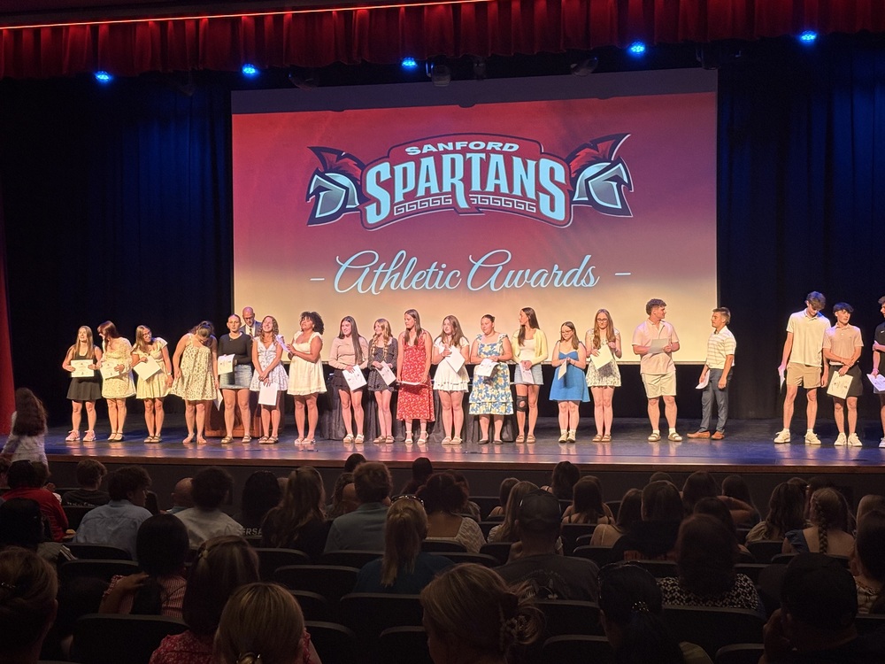 Sanford High School recognized dozens of student-athletes for academic achievement, leadership, and athletic performance at its Spring Sports Awards Recognition Night on Monday, June 8, in the Performing Arts Center.  The evening began with recognition of academic excellence, as SHS Athletic Director Zach Lemelin honored students who achieved a cumulative GPA of 92.5 or higher. More than 50 athletes earned All-Academic certificates, led by 25 honorees from the outdoor track and field team and 11 from varsity girls tennis. Baseball, softball, boys and girls lacrosse, and boys tennis rounded out the academic honors, with recognition extending to JV athletes as well. Coaches then presented individual sport awards showcasing the talent across Sanford's spring athletic programs. The baseball team celebrated Most Valuable Player Matthew Hebert, who swept multiple honors on the night. Cayden Gendron received the Coaches Award, Jack Stimmell earned the Spartan Award, and Cody Lockard was recognized as the team's Unsung Hero.  The softball program honored Faith Martel with the Spartan Award and Laelani Morris with the Coaches Award, while Reese Beaudoin was named Rookie of the Year. In girls lacrosse, Natalie Nadeau earned Defensive Player honors, Sophie Olivo received the Coaches Award, Paige Sevigny was recognized as the team's Utility player, and Zoey McCann took home the Spartan Award. Peyton White and Olivia Kezar shared Rookie of the Year recognition. Track and field celebrated standouts in both programs. Isaac Pelletier and Jack Van Gieson earned Most Valuable honors in track and field events, respectively, for the boys, with Avery Wedge named Rookie of the Year. For the girls, Jaslinn Johnson (track) and Mattea Peters (field) took Most Valuable honors, and Grace Cochrane was Rookie of the Year. In tennis, Elijah Bowden was named Most Valuable for the boys, with Brody Hartman earning Most Improved, Elijah Laurendeau the Coaches Award, and Levi Mann Rookie of the Year. The girls team recognized Hailey Payeur as Most Improved, Amelia Fernandez as Outstanding Rookie, Olivia Adornetto with the Coaches Award, and Lyla Fiandaca with the Spartan Award. Several Sanford athletes also earned conference-level recognition. Hebert capped his standout season with the Freddy Parent Award for York County and Second-Team honors at catcher, while Drew Vessels made the First Team at second base, Gendron earned All-Defensive Team recognition at third base, and Ryan Alexander received an Honorable Mention. In girls lacrosse, Sevigny and McCann were named All-Conference, with Olivo and Evelyn Cole earning Honorable Mention and White selected to the SMAA All-Rookie Team. In softball, Beaudoin and Bree Tyler each earned All-Conference Honorable Mention.