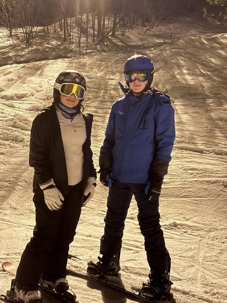 For the fourth year running, Sanford Middle School students are experiencing the thrill of winter through the school's popular Ski Club, and this year has seen the highest participation yet with 36 students. Sanford Middle School Math Teacher Penny Christie is the club's advisor, and has been passionate about bringing skiing back to Sanford schools since she arrived. "I've been wanting to start the ski club since I got here," Christie said. She previously taught at Willard, where Mr. Levasseur ran a similar program years ago. With strong support from administrators, Christie's vision became reality once COVID-19 restrictions were lifted. The club takes students to Pleasant Mountain for four trips throughout the winter, welcoming both skiers and snowboarders of all ability levels. With nearly 40 students on the mountain, safety remains a top priority. The program employs a comprehensive buddy system and hourly check-ins using a tracking system. Eight adult volunteers participate each trip, with four teachers stationed in the lodge and four on the mountain. For students like Jaxson Tranchemontagne and Rylan Delafontaine, the ski club offers a chance to spend time with friends and classmates. "It's been fun because when you go on the bus, you have people you know," Delafontaine said. Tranchemontagne, who snowboards, shared that his favorite part is "just snowboarding at the mountain." Both students plan to continue with the club throughout middle school. When asked if it's scary going down the mountain, Delafontaine acknowledged the challenge. "Not on the bunny ones, but like, halfway up the mountain, it's kind of steep," he said. "It's just because you can see everything around." The program welcomes complete beginners who take their first lessons on the conveyor belt in the beginner area, as well as more experienced students who tackle challenging runs higher up the mountain. Christie finds special joy in watching newcomers discover the sport. "Just the pride in their face. Some will say 'oh, Miss Christie, come look and see what I'm doing,'" she said. "It's so cool." After students complete their lessons, Christie often joins them on the chairlift, sometimes even accompanying them all the way to the summit. All eight adults who make the trips possible are volunteers, something Christie doesn't take for granted. "We're all volunteers, so it's really great. I feel really lucky that we get to do it," she said. The trips also provide a welcome break during the winter months for both students and staff. "It's nice to see the kids in a different light," Christie explained. "It's different when you're skiing."