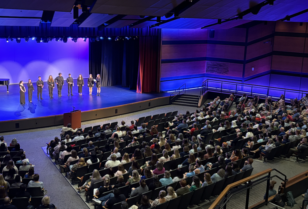 The Sanford School Department recently hosted its annual District-Wide Welcome Back Event at the Sanford Performing Arts Center, bringing together faculty, staff, and administrators from across all schools to celebrate the start of the 2025-26 academic year. The gathering began with a performance from the Sanford High School Chamber Singers, featuring students Ava Allen, Callia Curtis, Avila Cyr, Rebecca Horton, Jordyn Martin, Cynthia Carroll, Keaghan Gagnon, Will Kane, Logan Hamblin, and Evan Lynch. Under the direction of Sanford High School music teacher Ryan Geary, these students took time to rehearse during the summer before taking the stage. Following their musical presentation, each student introduced themselves, shared which schools they attended, and spoke about teachers who've had a lasting impact on their academic journey so far. School Committee Chair Amy Sevigny then delivered opening remarks that challenged both new and veteran staff members to be supportive colleagues. "I want you to all think about when you were that new person on the job, whatever job that was. Do you still remember the first person or the people that welcomed you and made you feel part of the team?" She challenged staff to be supportive, collaborative, encouraging, respectful, and positive colleagues. Whatever the day brings, be the coworker that you want to have. Because a strong school community thrives when each member feels valued and supported. Sanford Superintendent Matt Nelson expressed deep gratitude for the collaborative efforts throughout the district. "I want to thank you as our faculty and staff for all that you do for our students and what you do each and every day with them," Nelson said. A significant portion of the event welcomed new staff members joining the Sanford team across all district schools, including all elementary schools, middle and high school, SRTC and SCAE Adult Ed. The presentation also included Superintendent Nelson introducing the district's updated mission to "prepare all students with future-ready skills and knowledge to empower success in a rapidly changing world" for the first time to staff after it was recently approved by the School Committee. This mission is supported by Core Principles and Beliefs on Learning that focus on creating safe learning environments, developing future-ready skills, ensuring equitable access, adapting learning systems, and strengthening community collaboration. These principles work together to support the district's Portrait of a Future-Ready Graduate vision, preparing students to be critical thinkers and creative problem-solvers, emotionally intelligent collaborators, adaptable and resilient individuals, engaged citizens, and lifelong learners.