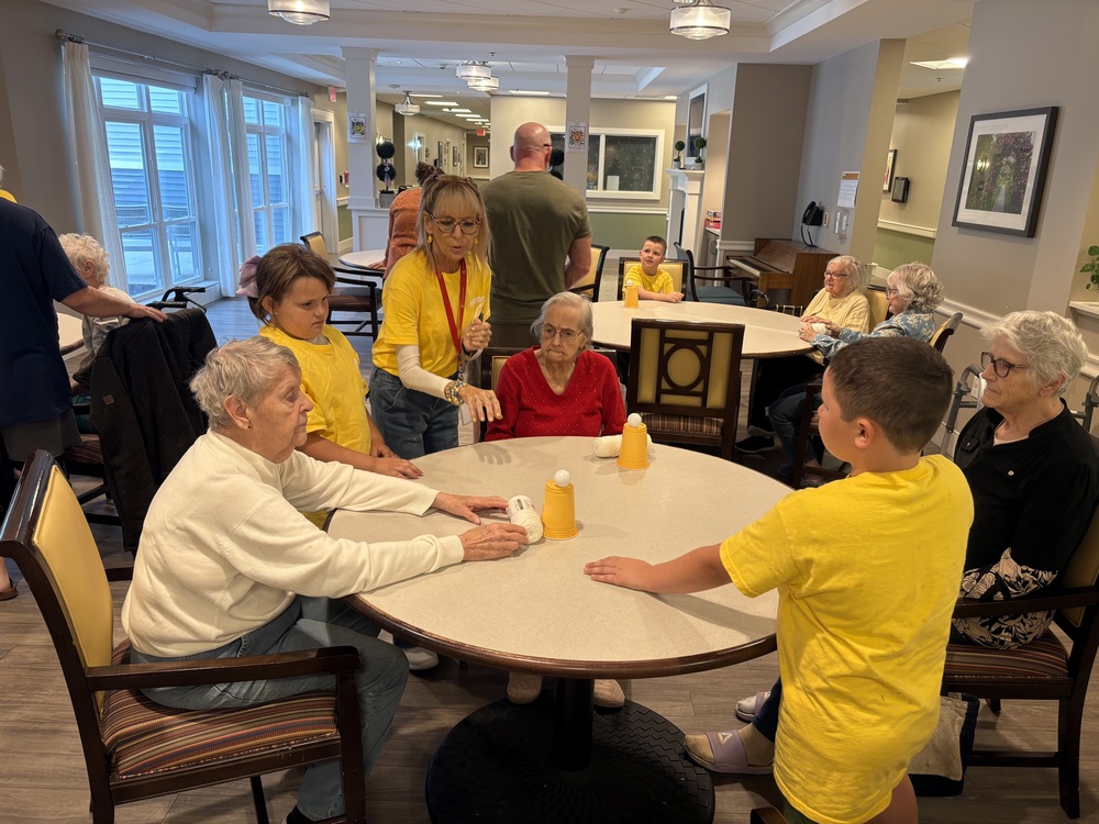 On the first Friday of each month, elementary and middle school students from Sanford’s BRIDGE Program visit Summer Commons Nursing Home to play games and make crafts with senior residents. It’s a partnership that started last year and has quickly become a highlight for both the students and the residents.   During last year’s visits, students prepared crafts in advance, then taught the residents how to make them – a process that built confidence and communication skills while bringing joy to the seniors.   "This visit is part of helping them interact and learn appropriate social skills," said Sandra Hewitt, an Ed Tech at the BRIDGE program.   On Friday, October 3, for the first trip of the school year, students brought a challenging game: plastic cups with strings attached. Students placed ping pong balls on top of the inverted cups, and then residents worked to pull their cups closer using the strings while trying to keep the ball balanced on top.  "I was able to get mine all the way to the end of the table without it falling," said Wyatt, a BRIDGE student.  The BRIDGE is a specialized program that recognizes some students face challenges that can interfere with their educational success. The program works with students who need additional support developing behavioral and social skills, offering specialized instruction, effective education, and counseling.   These monthly visits to Summer Commons provide a real-world setting where students can practice appropriate social interactions, develop empathy, and learn to engage respectfully with others  The structure of these visits—from preparing activities to teaching residents, maintaining line order, and using quiet voices in hallways—helps students build the foundational skills they need for success in traditional classroom settings.  These visits represent more than just a field trip—they're an integral part of students' growth and development.  The progress has been remarkable, according to Hewitt. Students who initially struggled with basic classroom expectations are now confidently leading activities and interacting appropriately with adults in the community.   "The interaction between the residents and the students are amazing, and everyone benefits from this time together," Hewitt said.