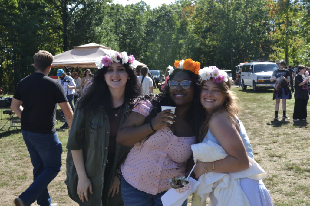 Three girls wearing flower crowns pose for a picture.