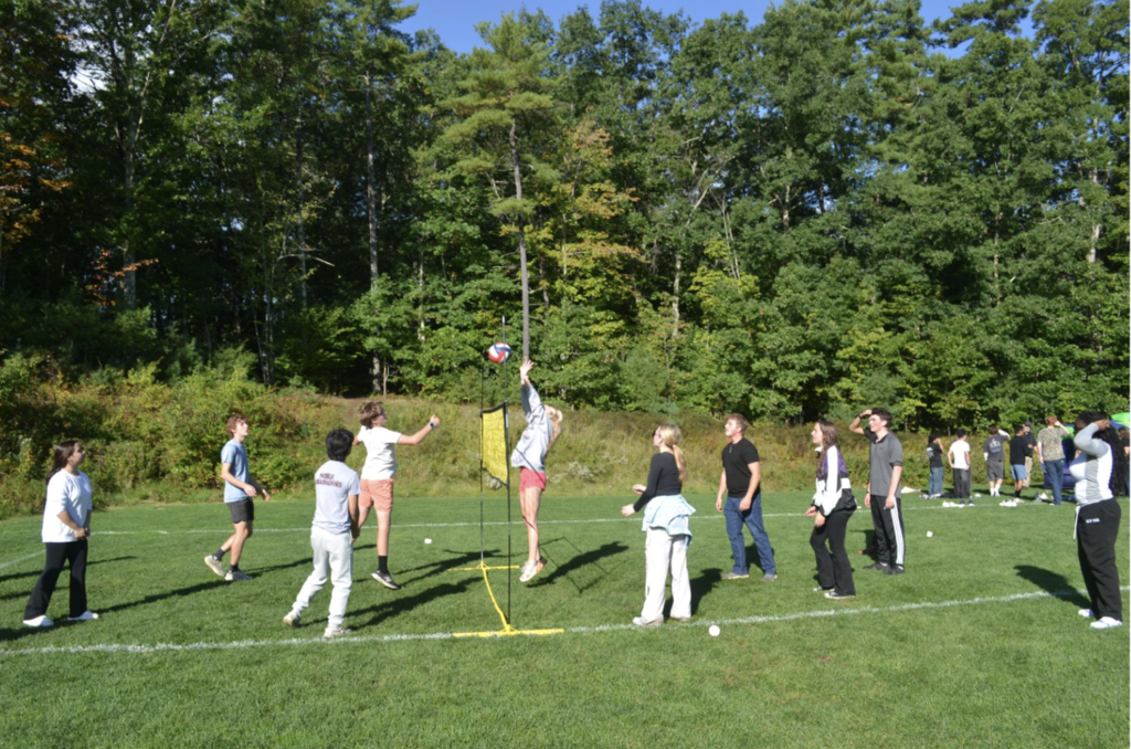 Students play volleyball together.