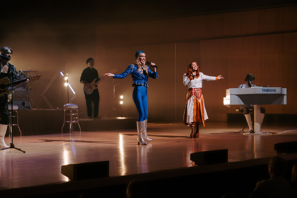 Two women sing on stage.
