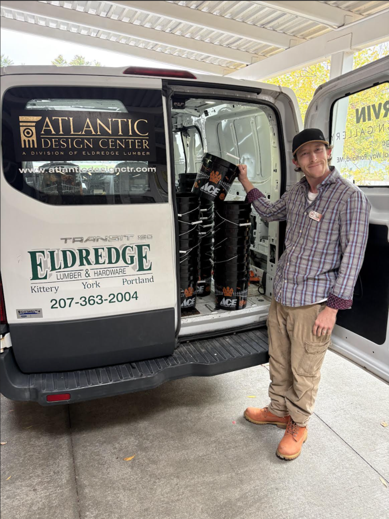 Man holding a BOO bucket next to an Eldredge Lumber truck.