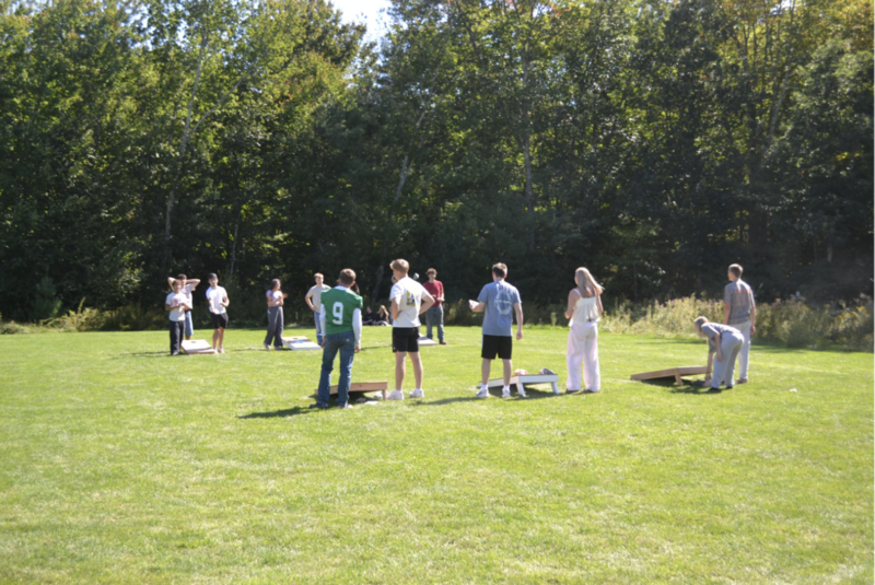 Students playing corn hole outdoors.