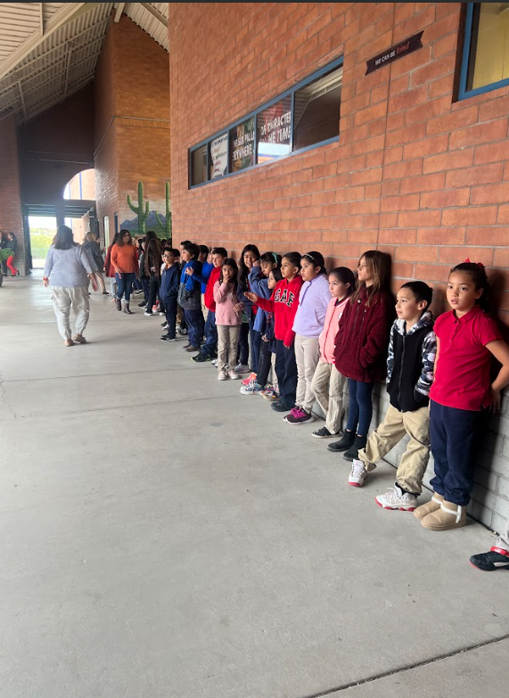 Older students lined up against a wall.