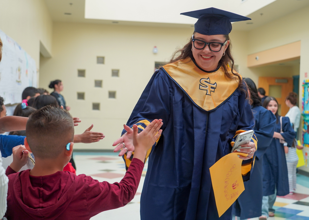 graduate high fives younger student