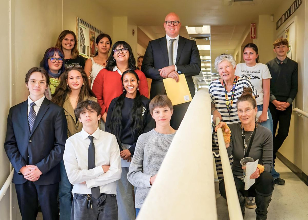 New Mexico Supreme Court Chief Justice David Thomson poses for a photo with students at Mandela International Magnet School.
