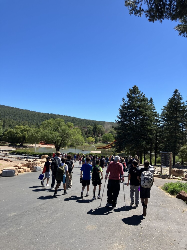 A group of 7th grade students walk toward the lake at Glorieta