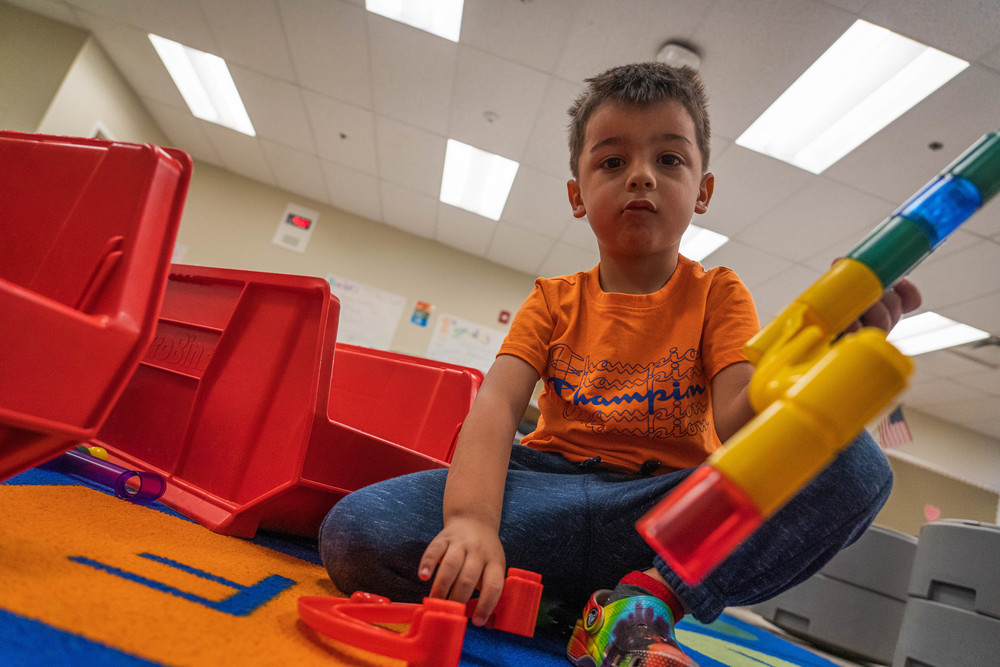 kindergarten boy playing with stacking blocks