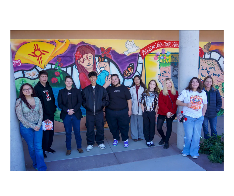 Students standing in front of mural. 