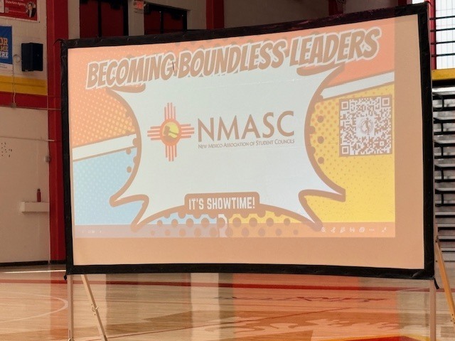 A projector screen displays a presentation titled "Becoming Boundaries Leaders" with a QR code and an image.