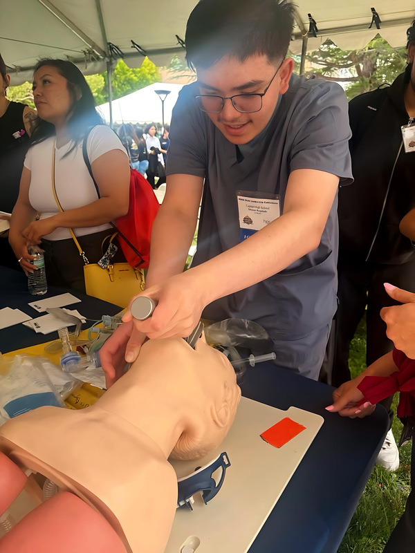 Osman Regalado, a Capital High junior, works on intubating a patient during the state conference. 