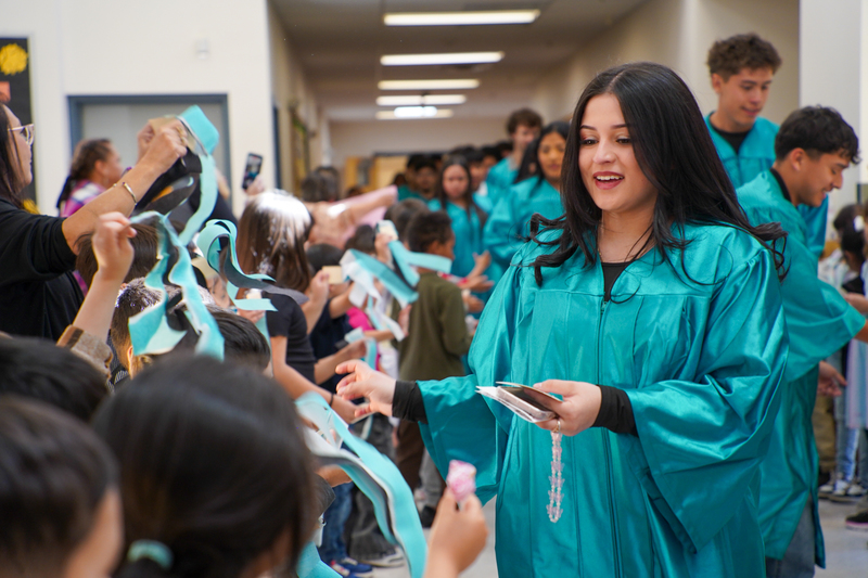 Joanna DeLeon hands out stickers to students at White Tiger Elementary during the CHS Graduate Parade