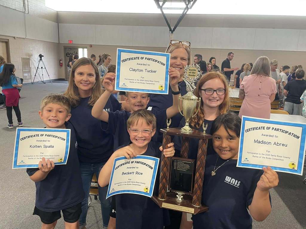 Ms. Cibula, Ms. Huggins and 5 students from Ms. Huggins class smiling with certificated and a large trophy.
