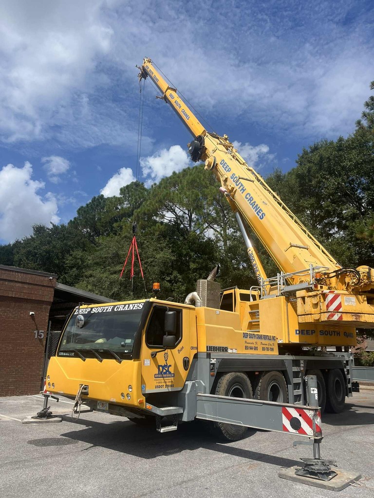 Crane placing the old HVAC system from building 1 to the HVAC/R Lab area for students to learn on .