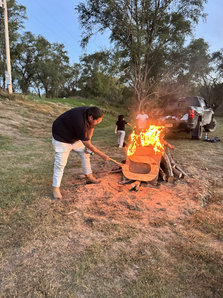 picture of staff member lighting the bonfire 