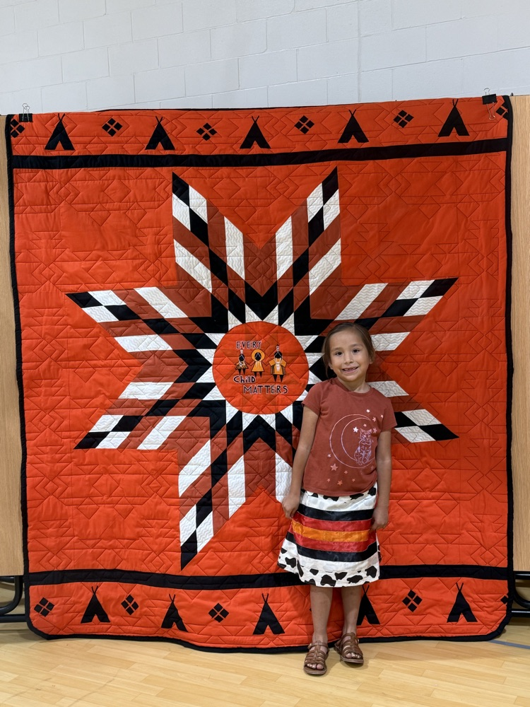 Elementary student with an every child matters quilt.