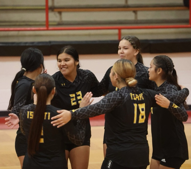 team picture of our volleyball team in their black jerseys hyping each other up